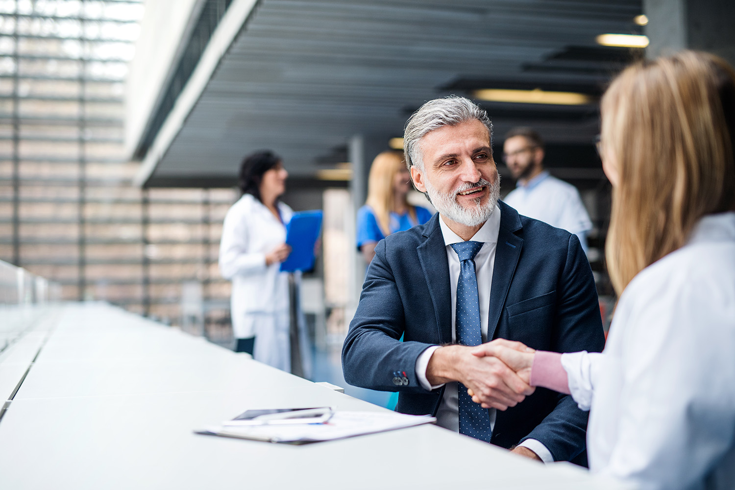 shutterstock_1675490173 couple talking to a woman at a desk